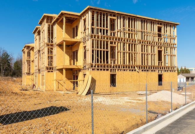 a temporary chain link fence in front of a building under construction, ensuring public safety in Dayton, MN